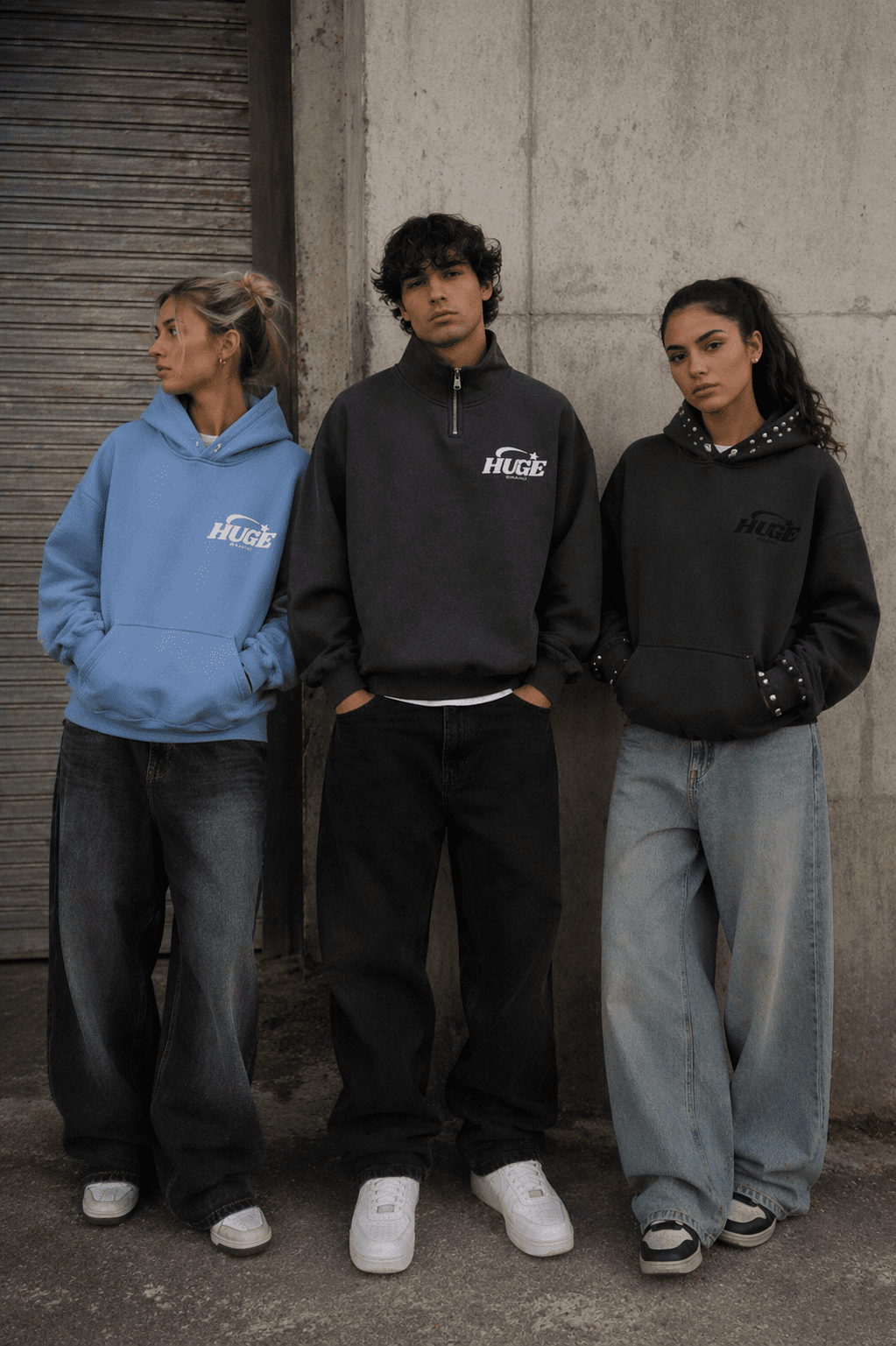 Tres modelos luciendo sudaderas streetwear Huge Brand en tonos gris y azul urbano